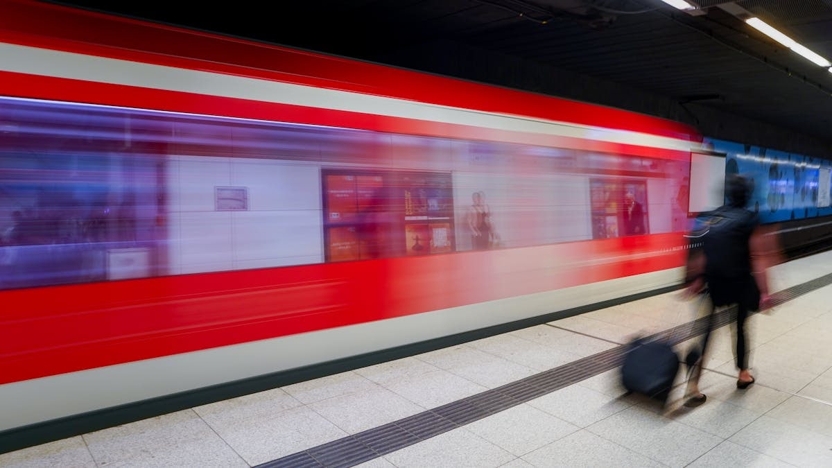 Dynamic scene at a Hamburg station with a speeding train and commuter.